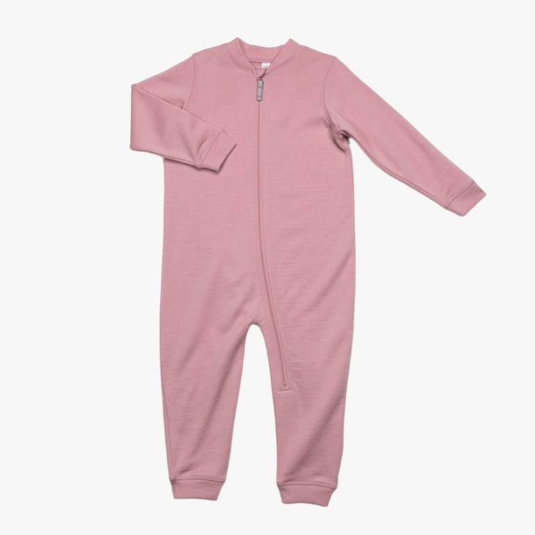 En støvrosa babyheldress med lange ermer, ben, hellang glidelås foran og vrangborder, flat lay.