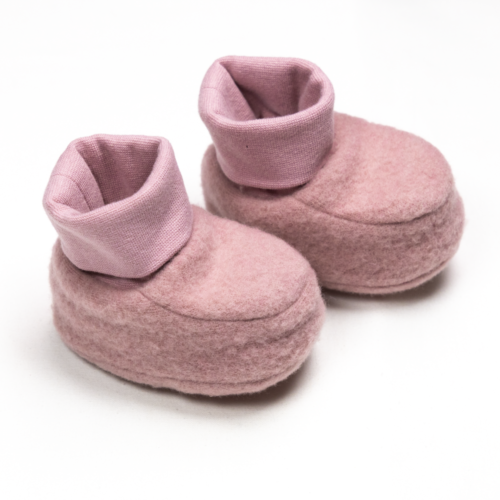To rosa babybooties i filt med ribbestrikkede mansjetter vises fra en litt hevet forside.
