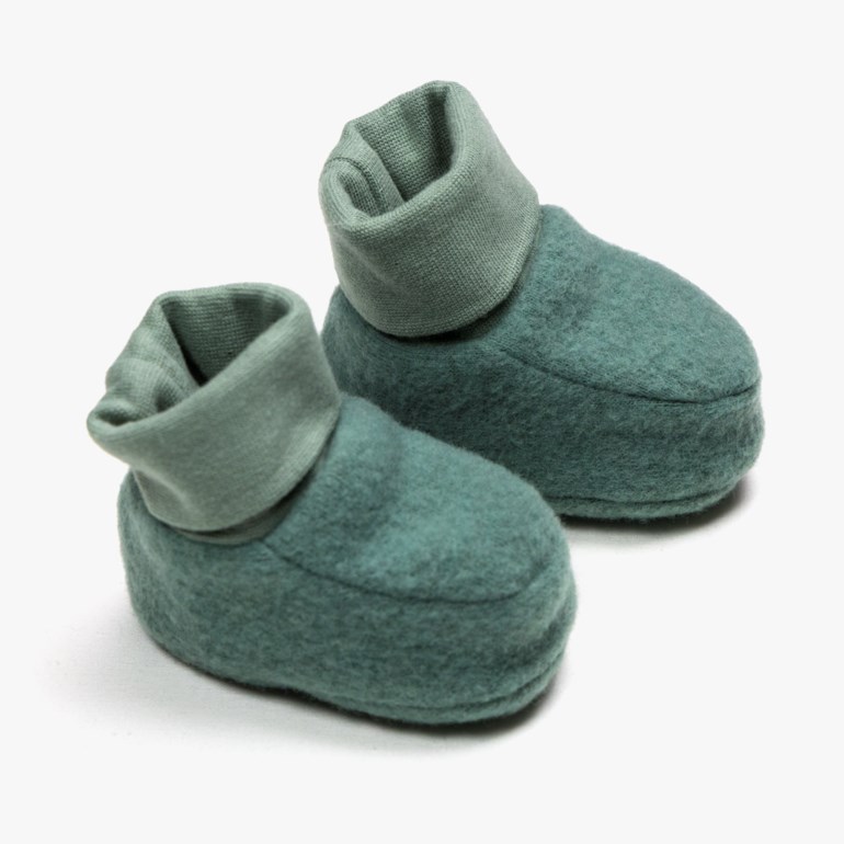 To grønne babybooties med filtkropper og ribbestrikkede mansjetter, sett forfra.
