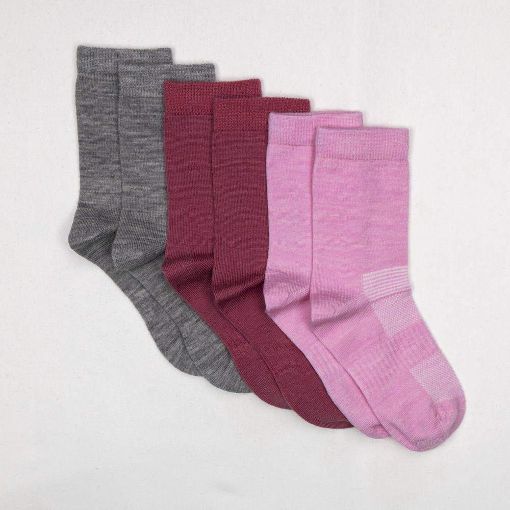 Tre par mellomhøye strikkede sokker i grått, mørkerødt og rosa.