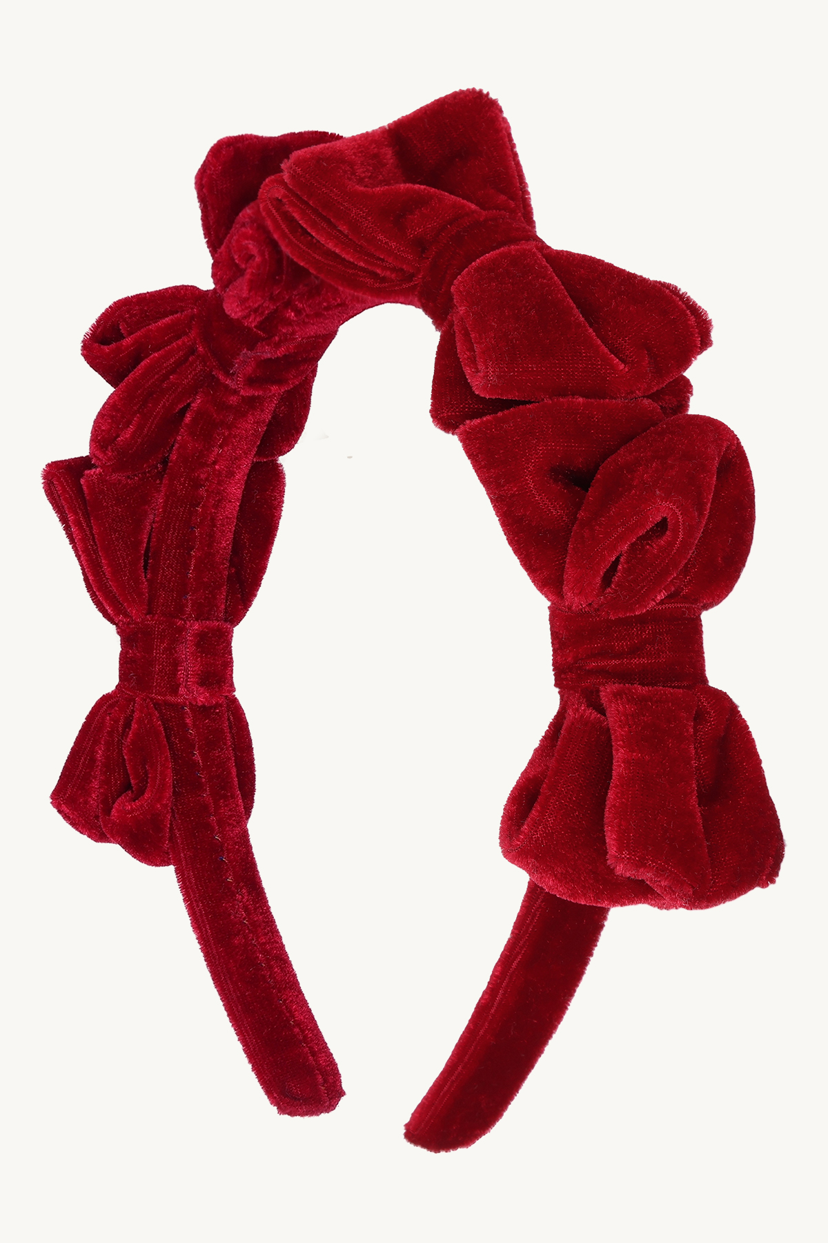 Frontvisning av et rødt fløyels pannebånd med flere voluminøse sløyfer.