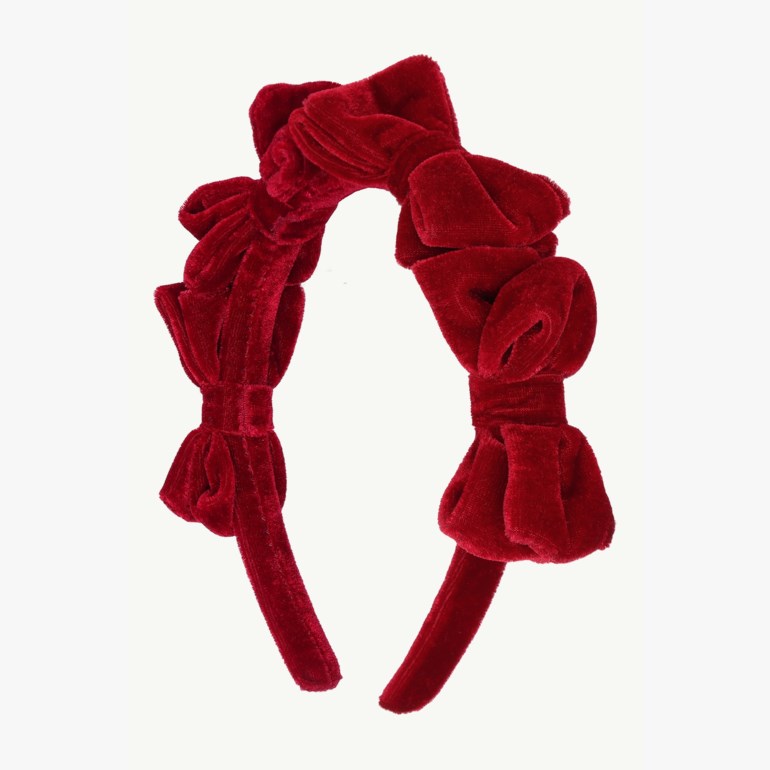Frontvisning av et rødt fløyels pannebånd med flere voluminøse sløyfer.