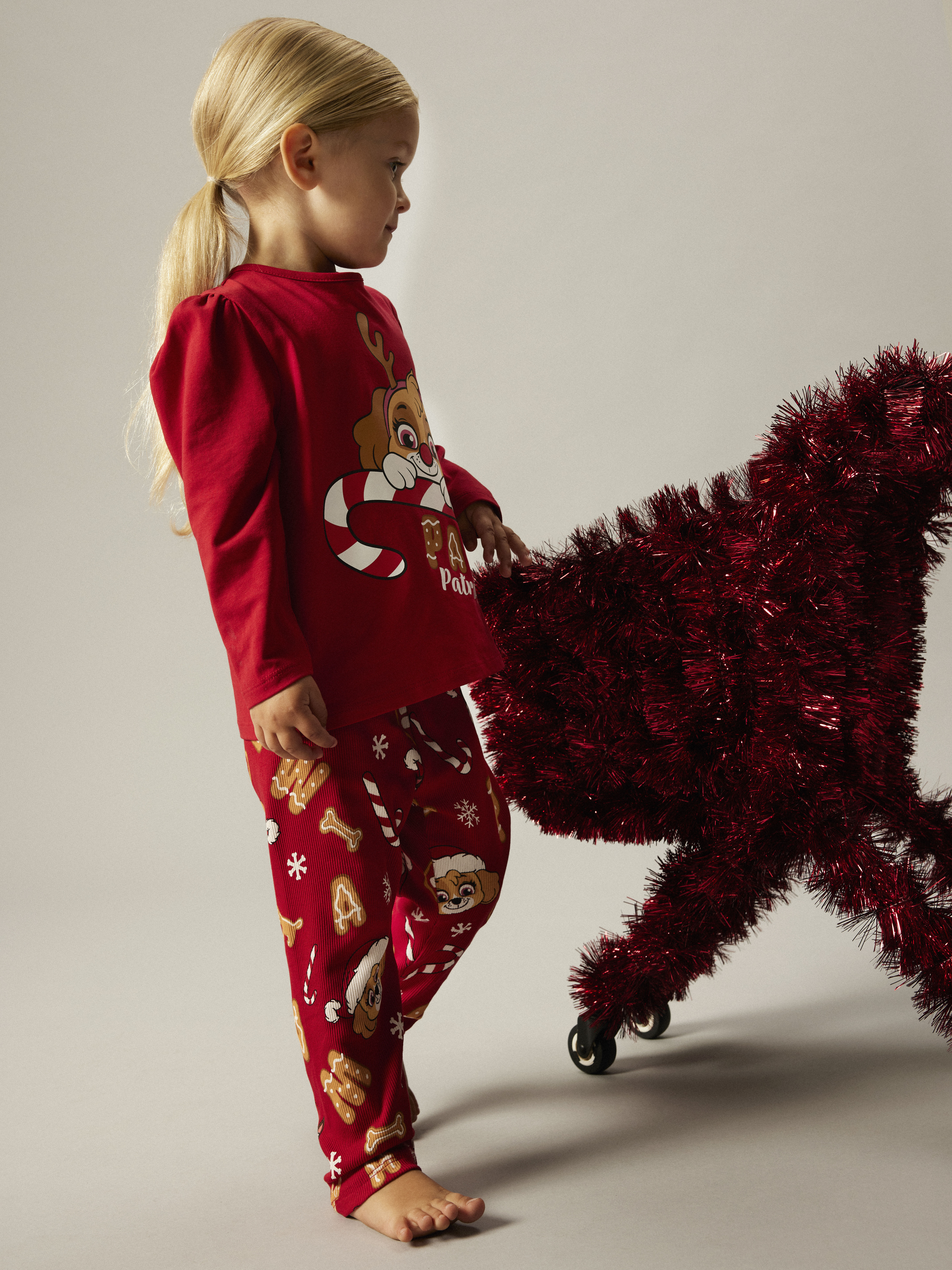 Rødt Paw Patrol julepyjamasett for barn, med trykt topp og mønstrede bukser.