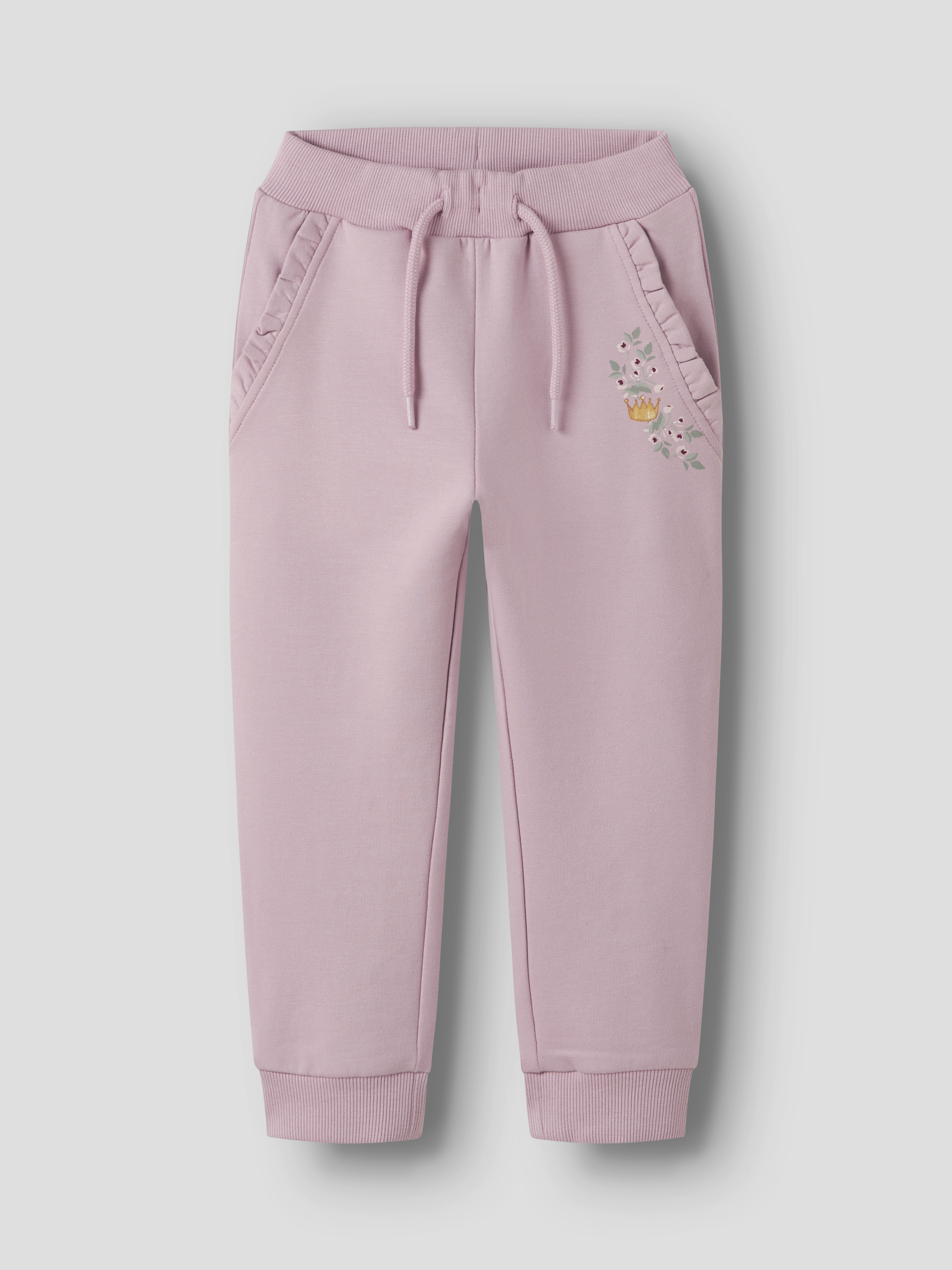 Rosa barnejoggebukse med snøring i livet, ribbekanter, volangkantede lommer og blomsterkronebroderi.
