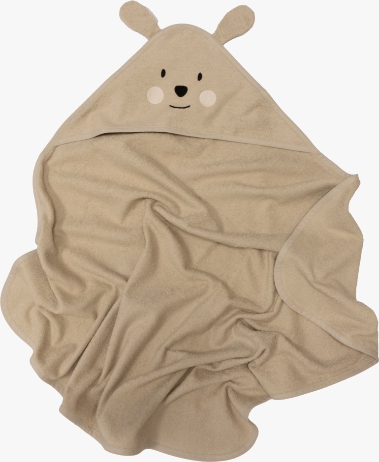 Et beige badehåndkle for baby med hette, bjørneører og brodert bjørneansikt, flattliggende.
