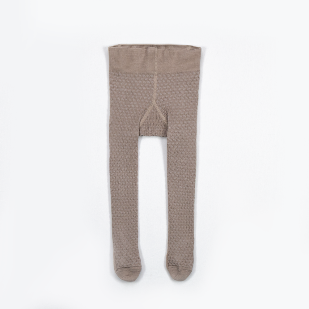 Beige barnestrømpebukse med strukturstrikk og ribbet midje, flatt sett forfra.