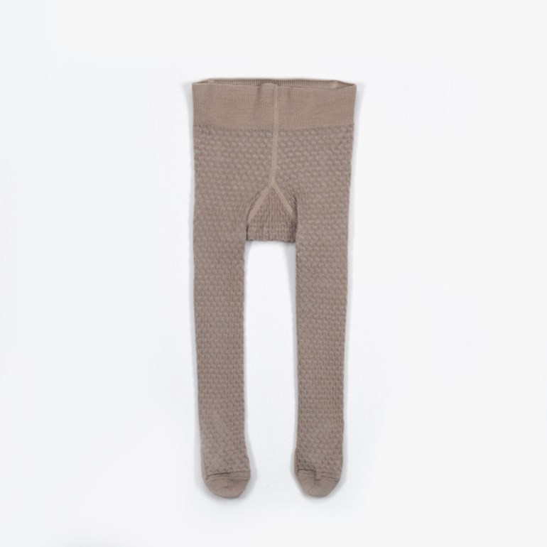 Beige barnestrømpebukse med strukturstrikk og ribbet midje, flatt sett forfra.