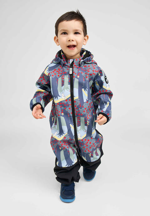 Barn har på seg en blå overall med skogs- og rødbærtrykk, glidelås foran og blå sko.