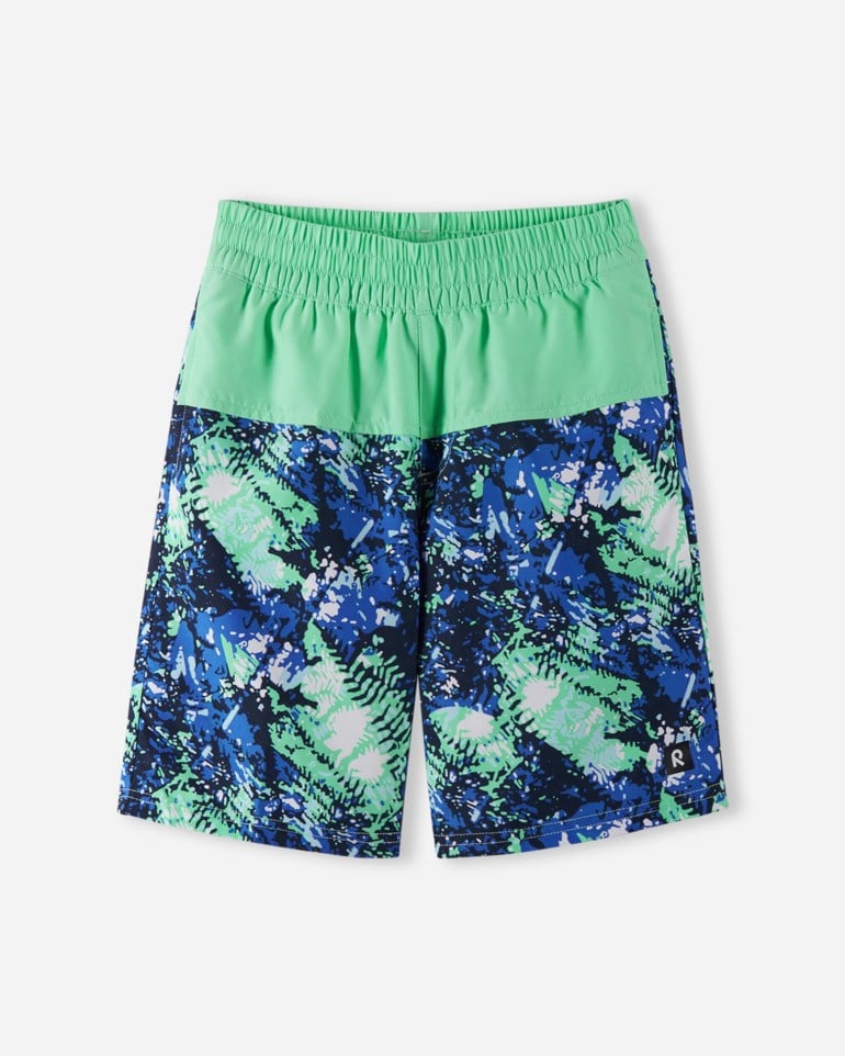 Barneshorts med blått og grønt mønster og ensfarget grønn elastisk linning, forfra, flat lay.