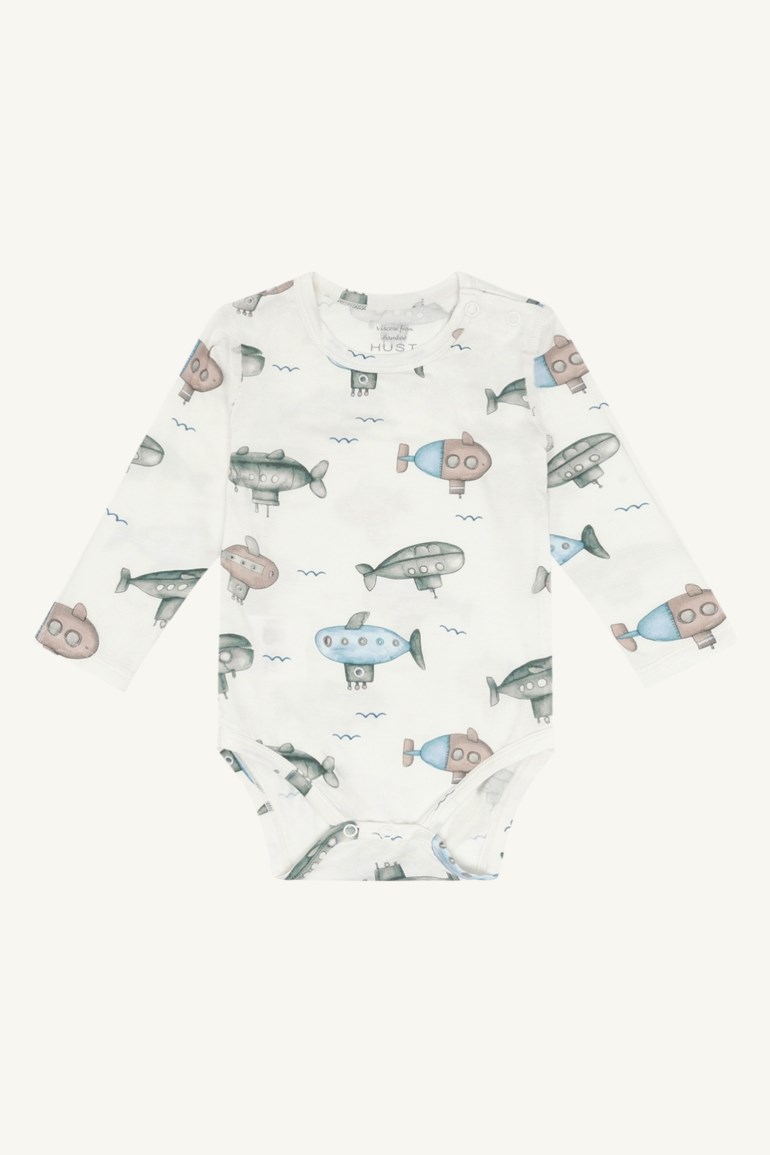 Hvit langermet babybody med fargerikt ubåt- og bølgemønster forfra, med trykknapper.