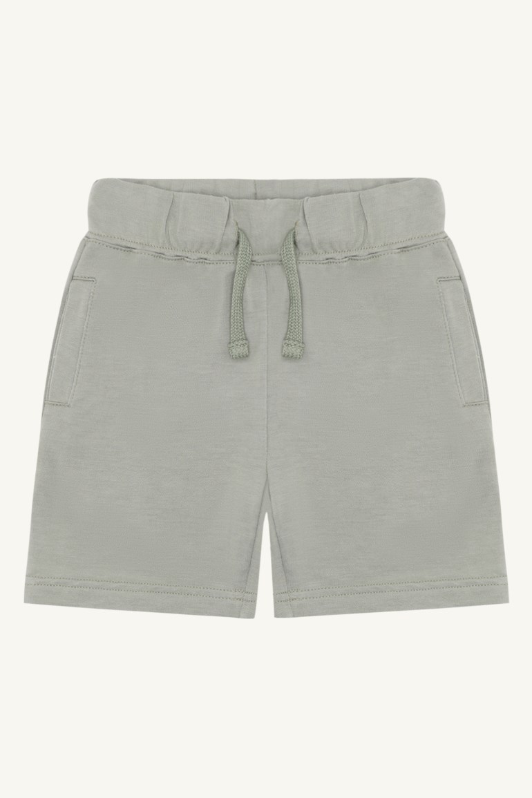Forfra lysegrønne barneshorts i sweatshirttøy med elastisk snøring i midjen og to sidelommer.