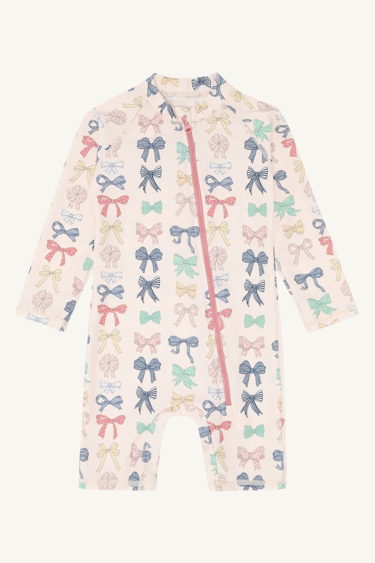 Baby langermet badedrakt med lysrosa bakgrunn, fargerikt sløyfemønster og en rosa glidelås foran.