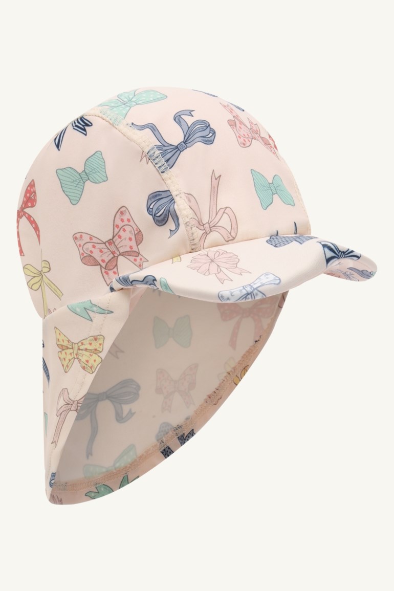 Lys rosa solhatt for barn med fargerikt sløyfemønster, brem og nakkeklaff, sidevisning.