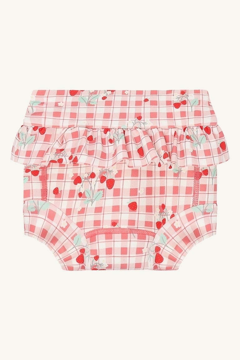 Babyens rosa og hvitrutete badebukse med jordbærmønster og volangkant i livet.