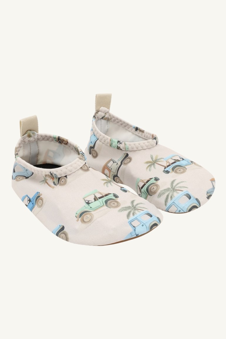 Par beige babybadesko med blå og grønne bil- og palmemønster.