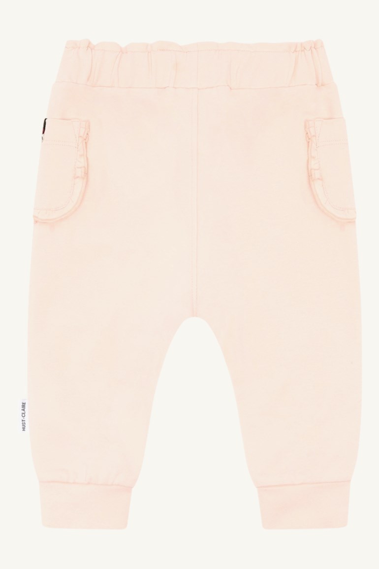 Baby lys rosa bukser med elastisk midje, rysjelommer og ribbestrikkede mansjetter, forfra.