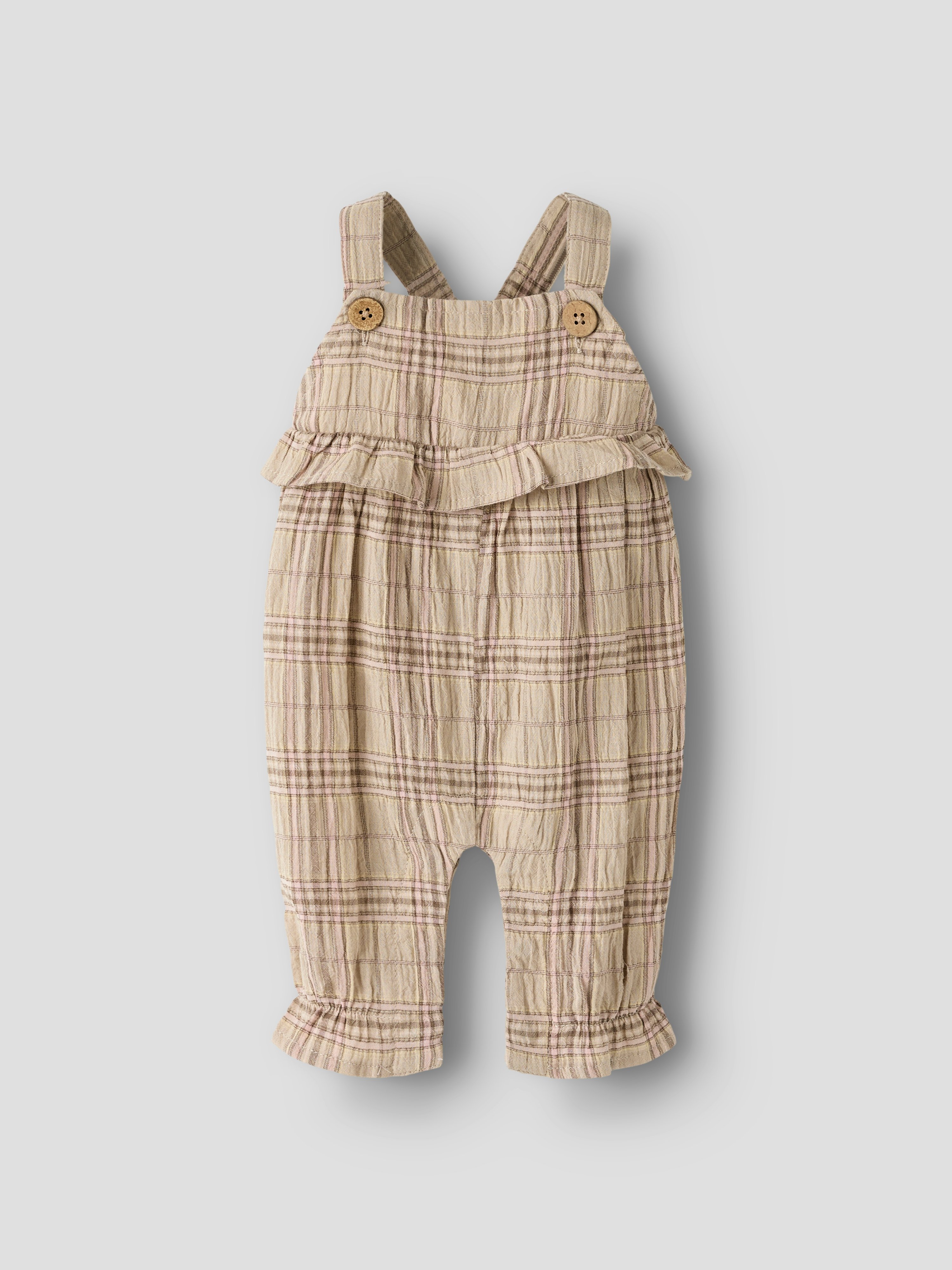 Frontbilde av en baby beige rutete sparkedress med skulderstropper, knapper foran og rysjer.