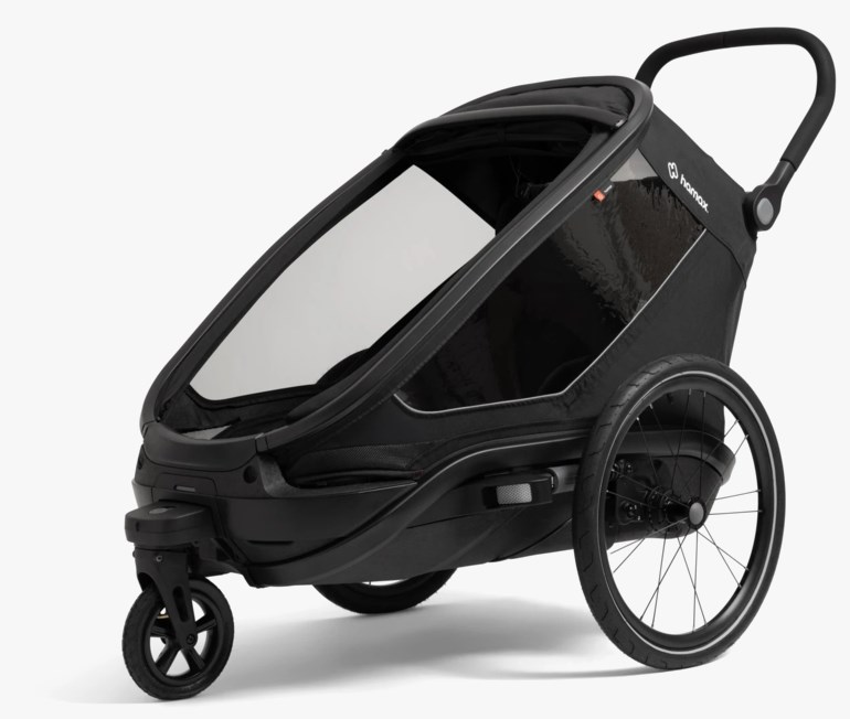 Svart sykkelvogn/barnevogn med klare vinduer, store bakhjul, lite forhjul og et håndtak.