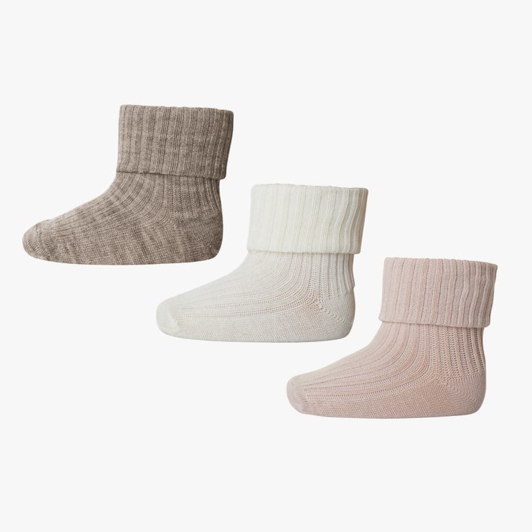 Tre par ribbestrikkede babysokker i lysbrun, off-white og lys rosa.