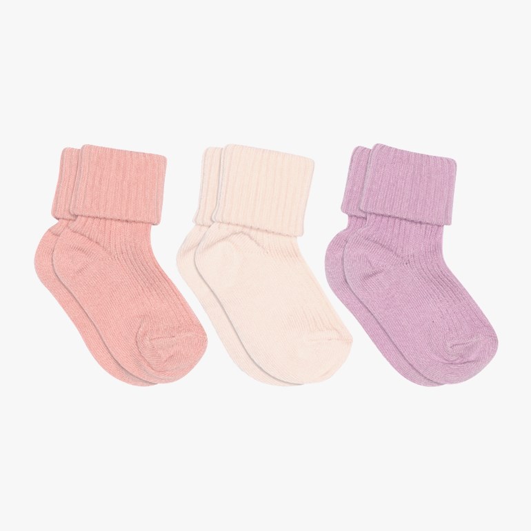 Tre par ribbestrikkede babysokker i lys rosa, kremhvit og lilla, hver med en brettet kant.