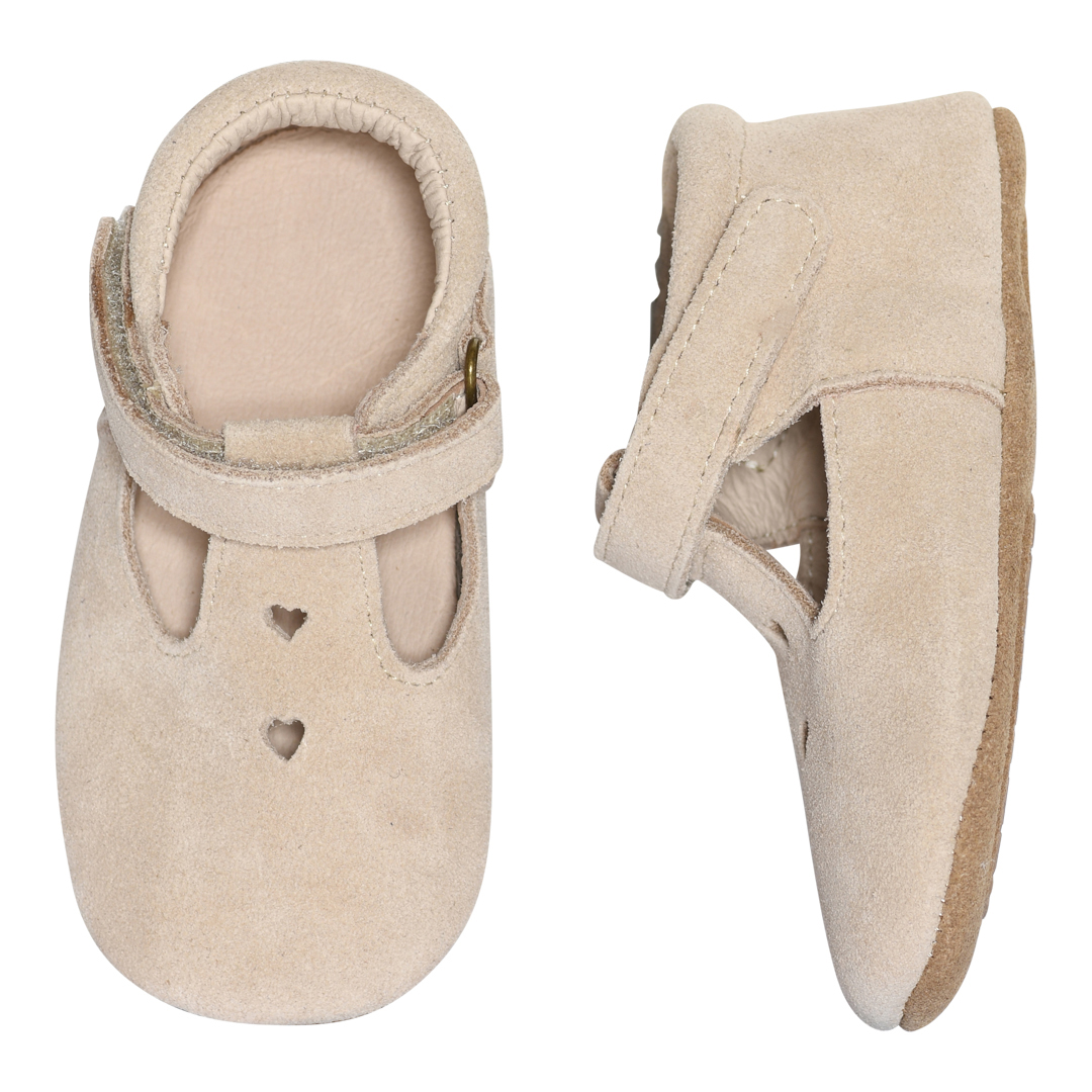 Lys beige semsket babysko, forfra med hjerteutskjæringer, sidevisning med stropp.