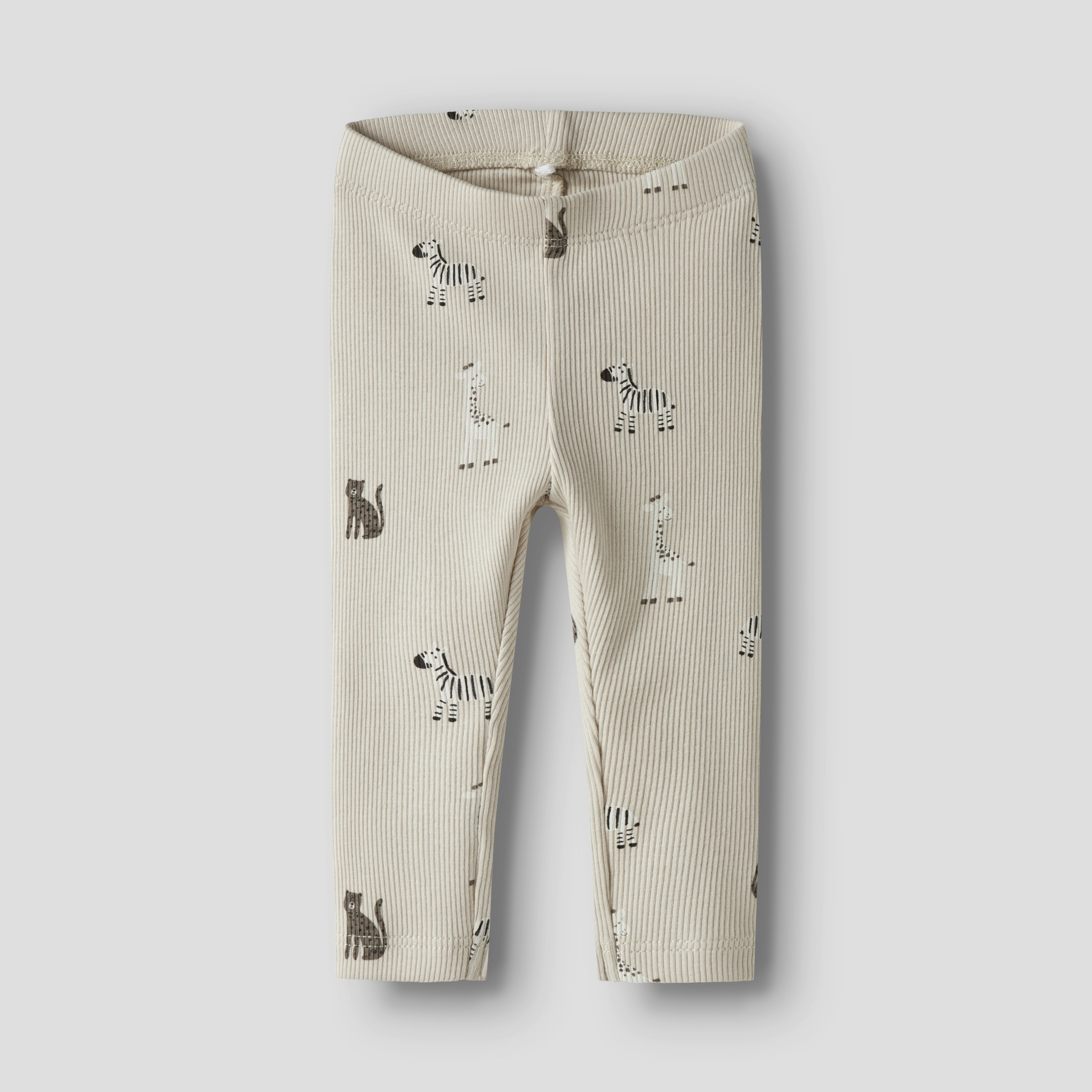 Forfra, ribbet beige baby-leggings med svart sebra- og kattemønster.