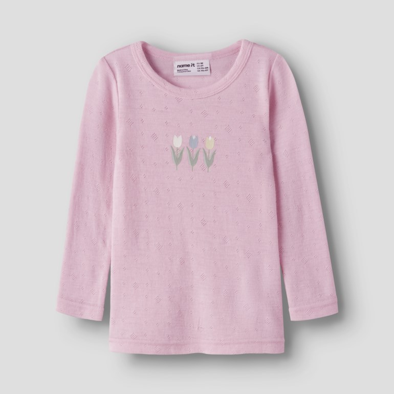 En rosa langermet barnetopp med teksturerte prikker og tre broderte tulipaner på brystet.
