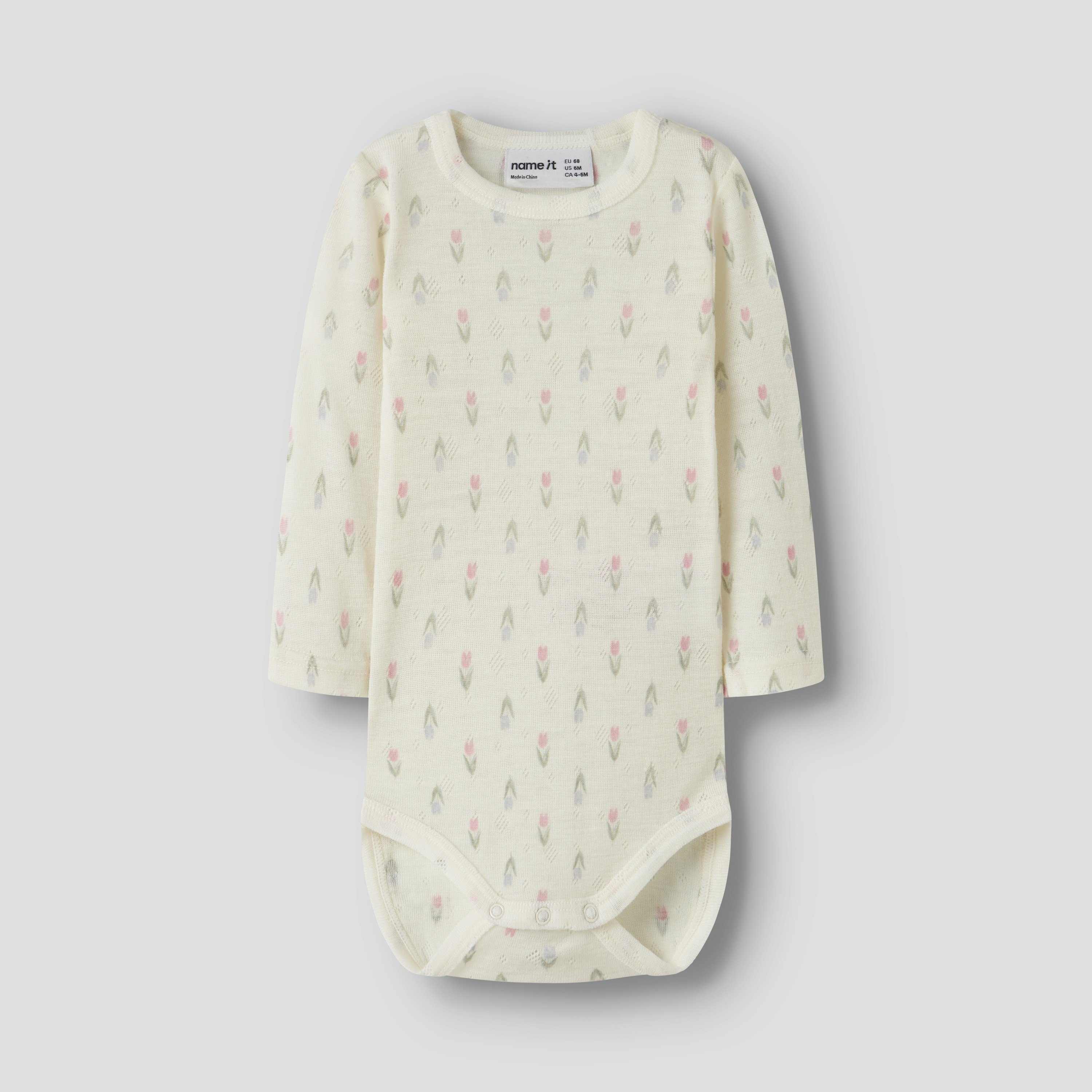 Baby langermet body i off-white med rosa og grått tulipanmønster og trykknapper.
