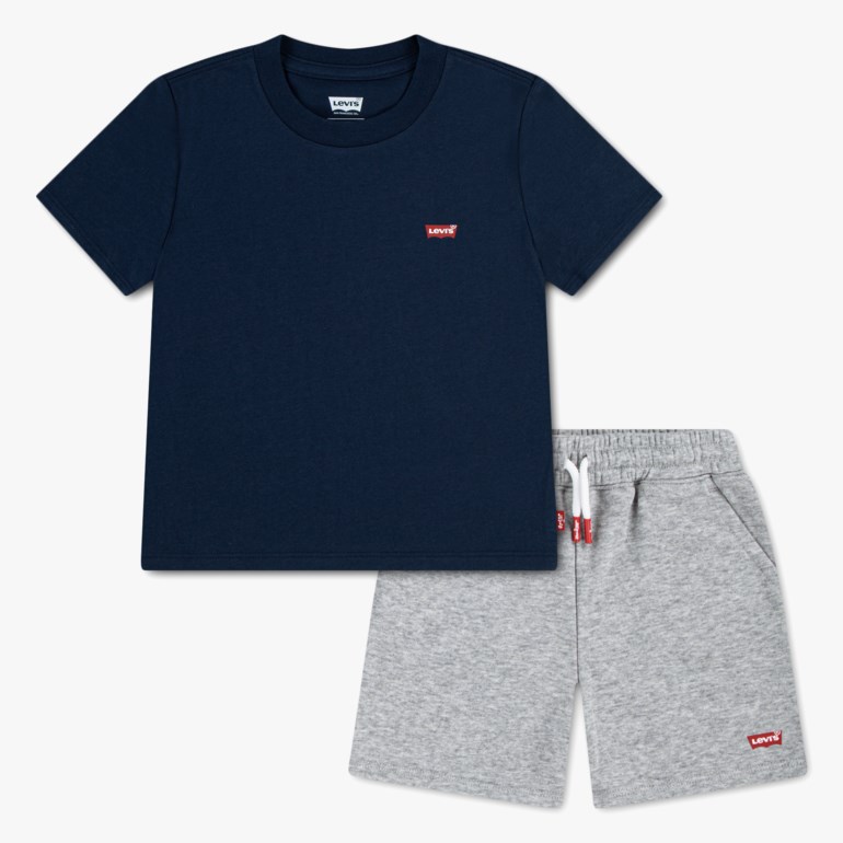 Barns marineblå kortermet t-skjorte med rød logo og gråmelert shorts med elastisk linning og hvite snøringer.