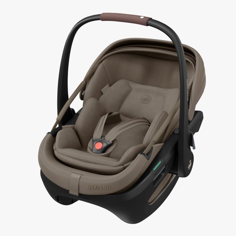 Brun og svart babybilstol med polstret innlegg, 5-punktssele og brunt skinntrukket bærehåndtak.
