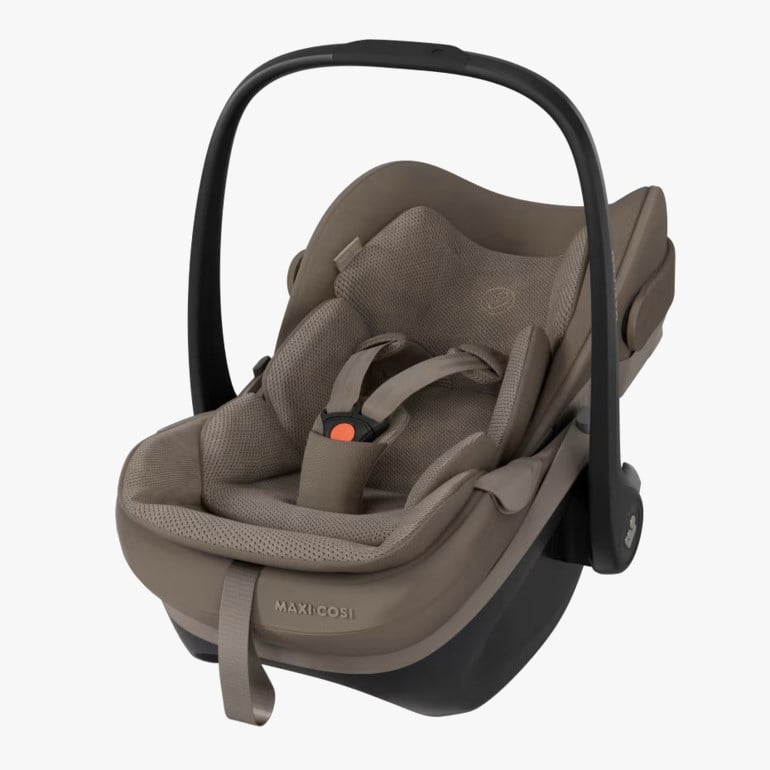 Beige babybilstol med svart håndtak, 5-punktssele med oransje spenne og mørk base.