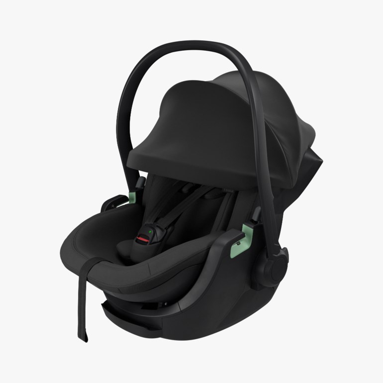 Svart babystol med kalesje, håndtak og lysegrønne detaljer, med fempunktssele.