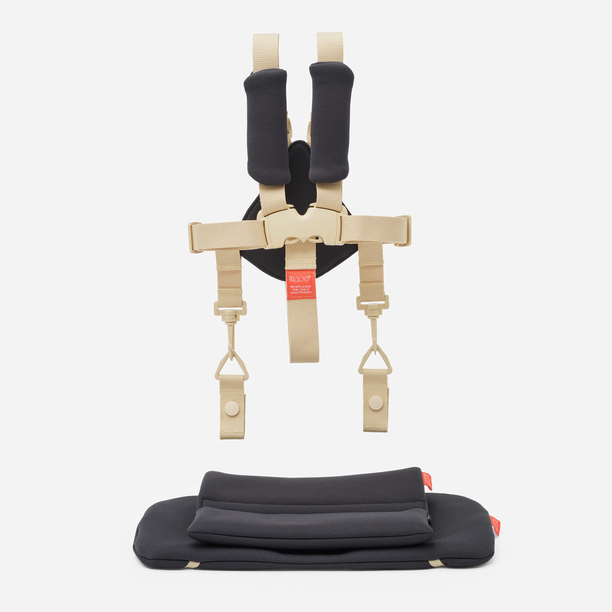 En beige babysele med svarte skulderputer og en matchende svart sittepute.