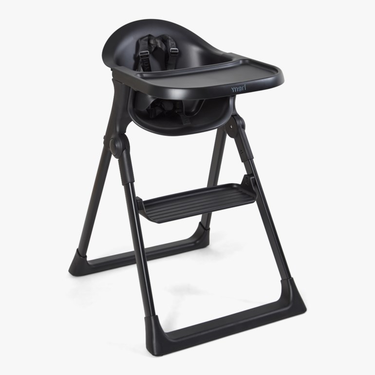 Svart babystol med brett, fotstøtte og sikkerhetssele.