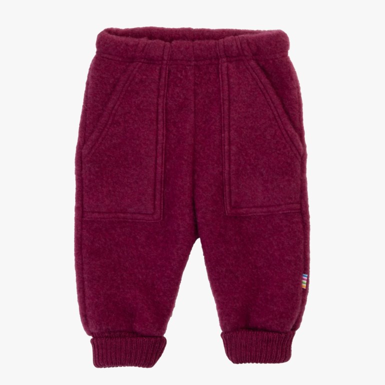 Forfra mørkerøde barnebukser i fleece med elastisk midje, to lommer og ribbestrikkede mansjetter.