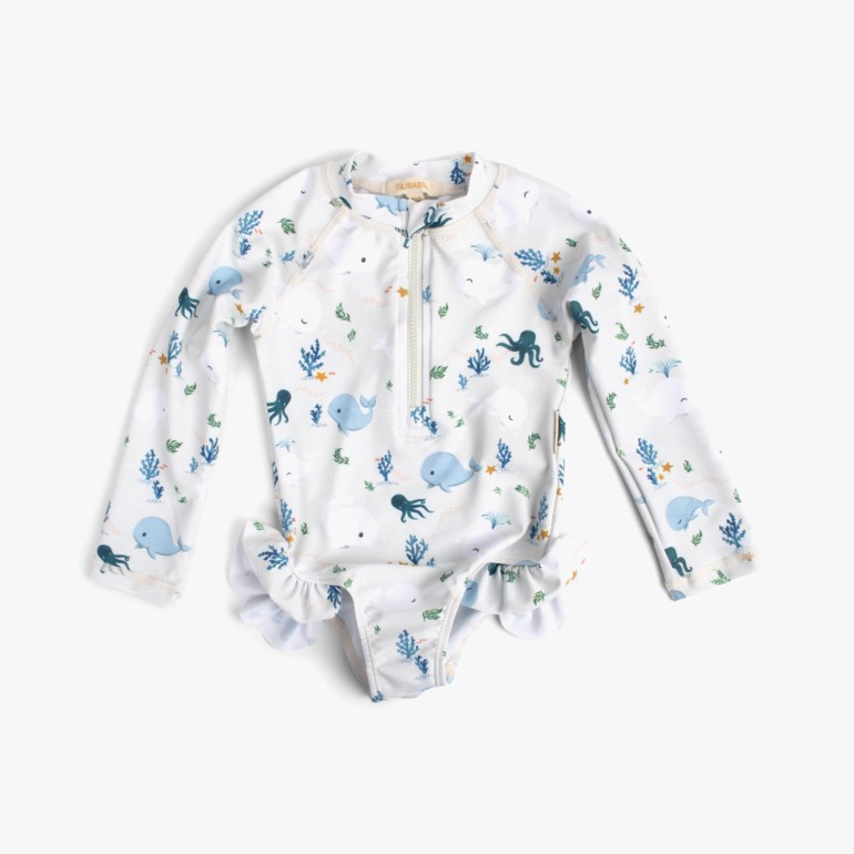 Baby langermet UV-drakt med hvitt, blått hval- og blekkspruttrykk, halv glidelås og volang ved bena.