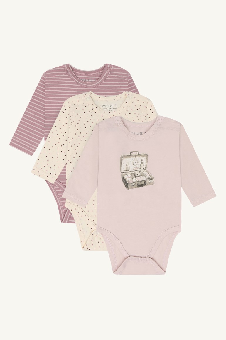 Tre langermede babybodyer: en lys rosa med koffertgrafikk, en kremfarget med prikker og en stripete lilla.