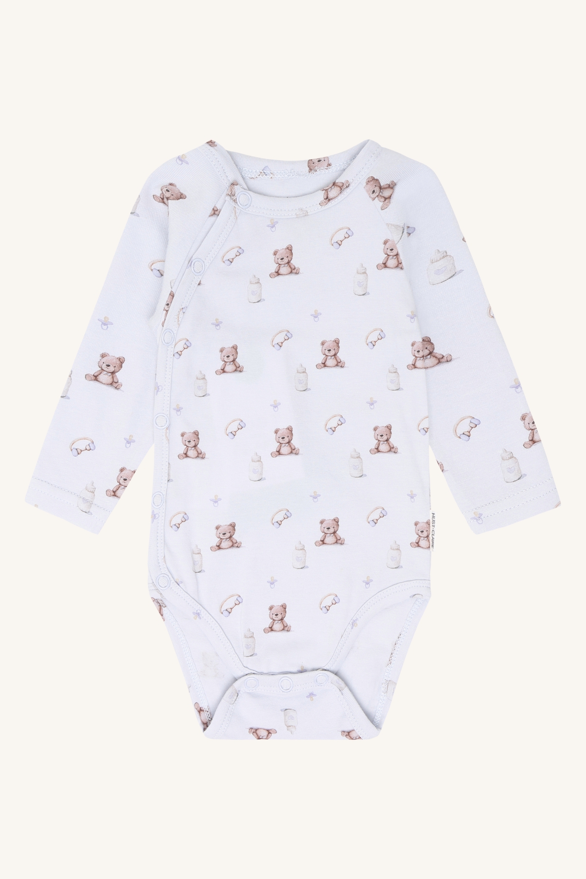 Hvit babyomslagssbody med lange ermer og trykk av bamser og tåteflasker, med trykknapper.