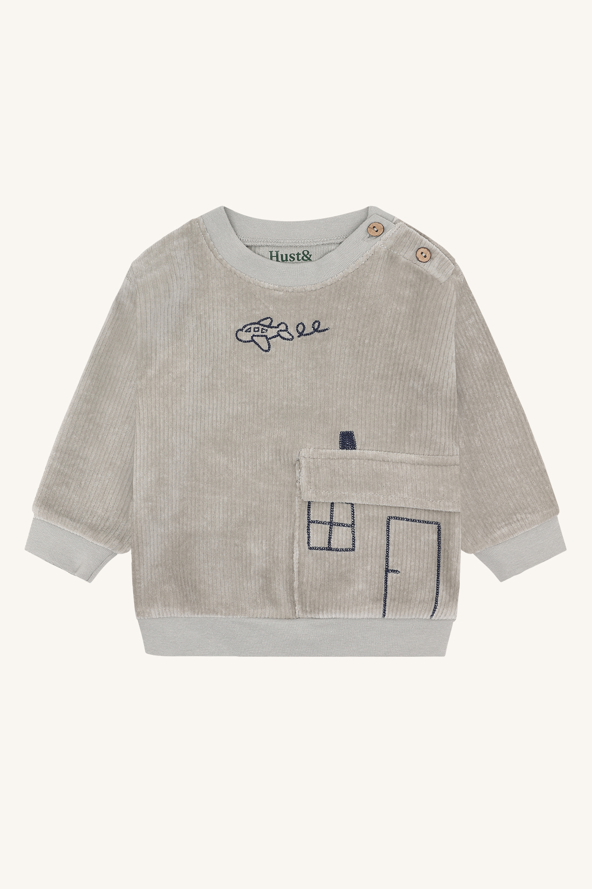 Frontutsikt av en babygenser i grå kordfløyel med skulderknapper, brodert fly og husdesign med lomme.