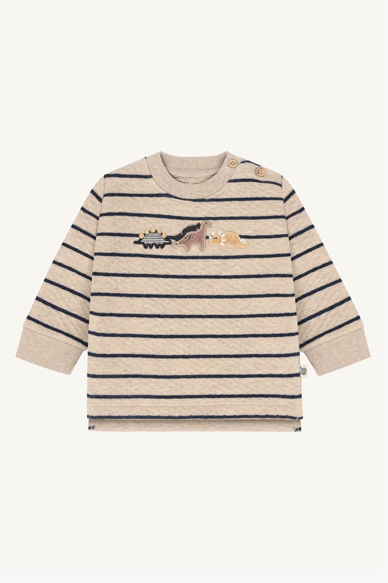 Babys beige langermet topp med marineblå striper, skulderknapper og dinosaurapplikasjoner, forfra.