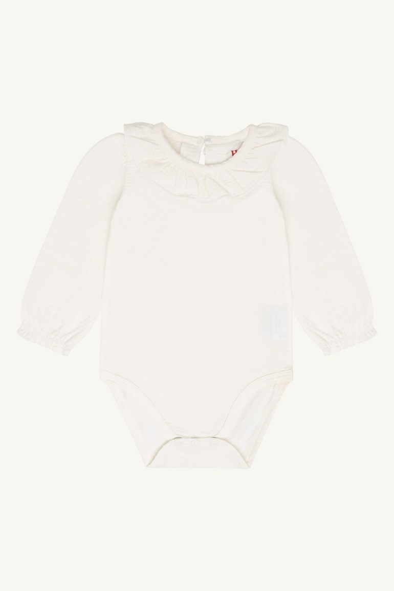 Forfra av en teksturert hvit langermet babybody med rysjekrage og trykknapplukking.