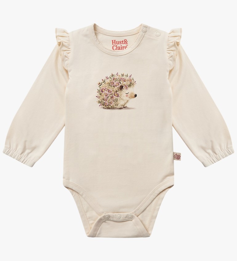 Lys beige langermet babybody med skulderkapper, trykk av et blomstret pinnsvin og trykknapper.