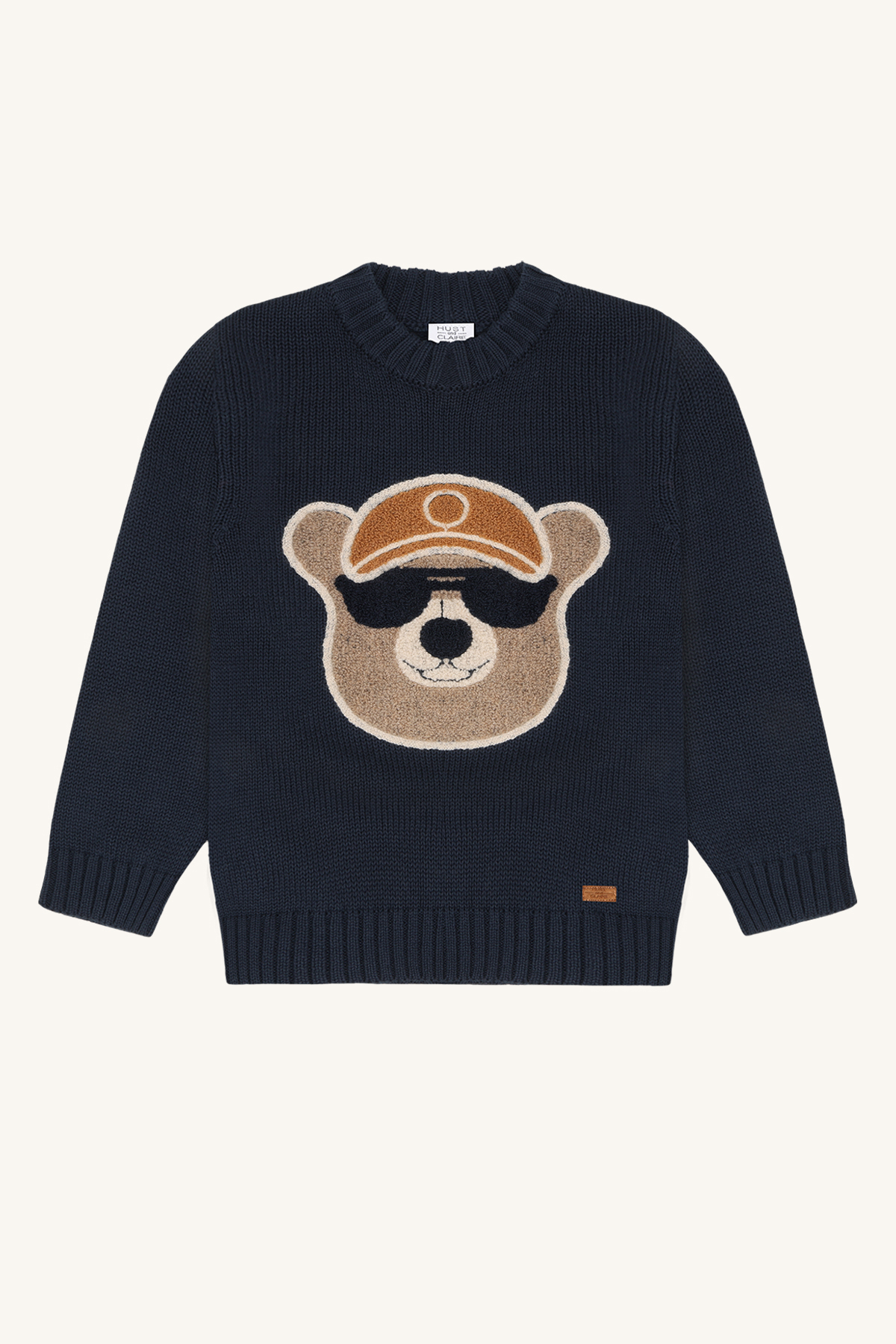 Barne mørkeblå strikkegenser med en brun bamse som har hatt og solbriller på forsiden.
