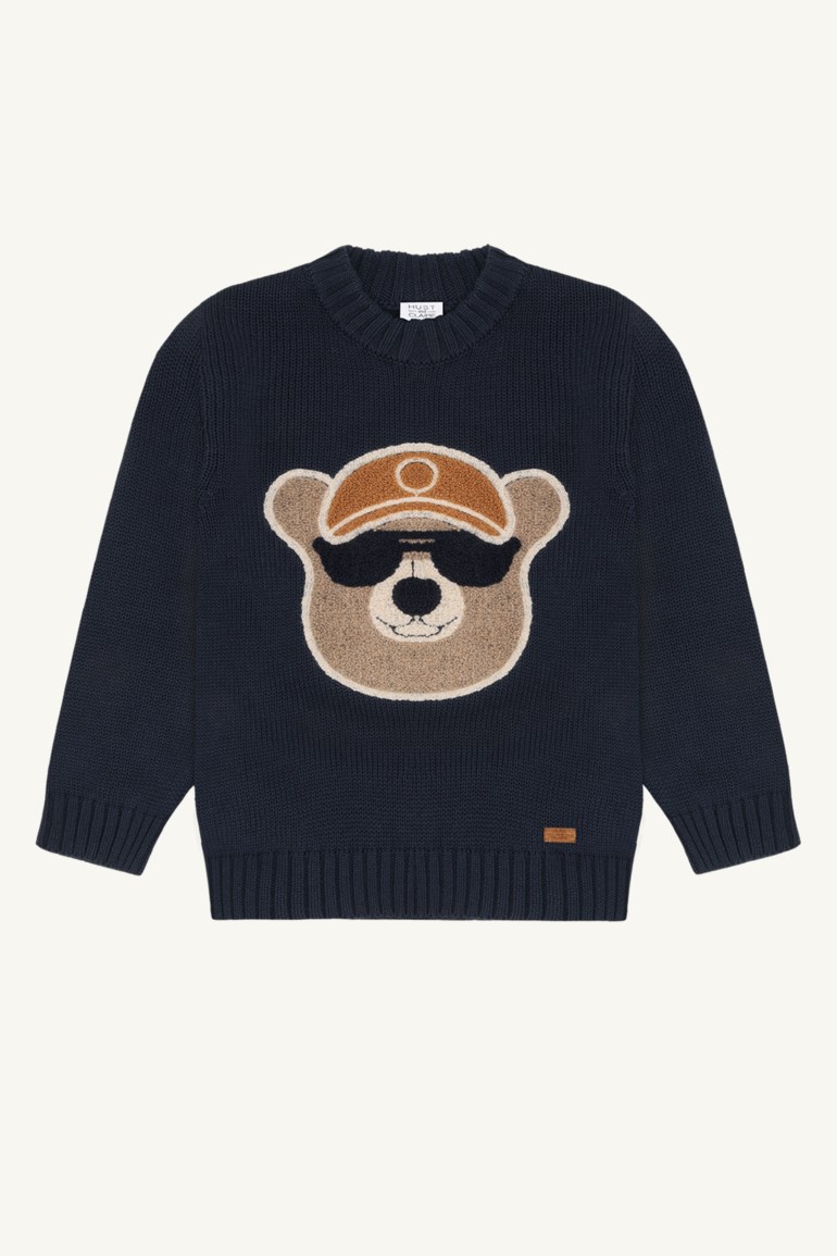 Barne mørkeblå strikkegenser med en brun bamse som har hatt og solbriller på forsiden.