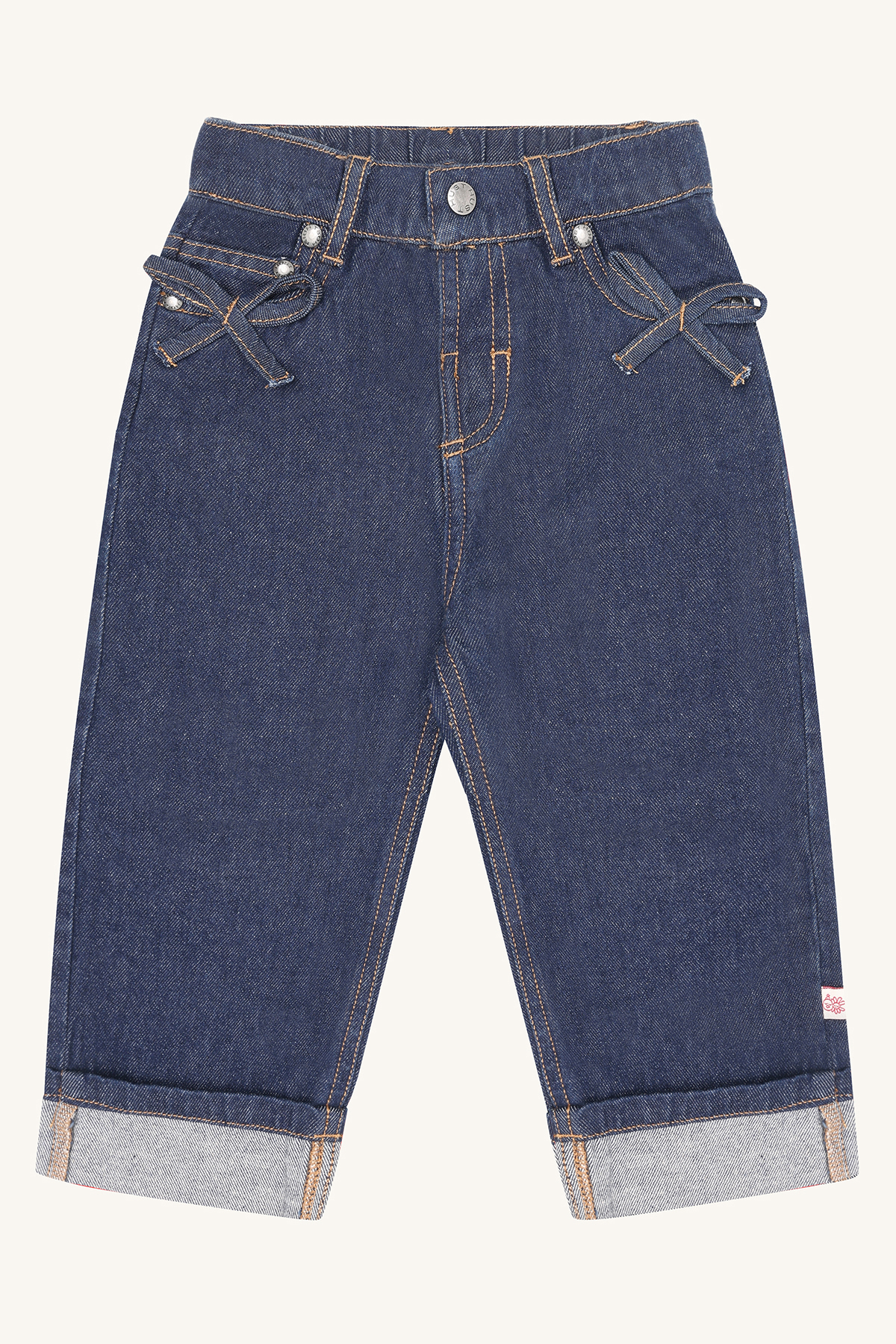 Mørkeblå barnejeans i denim med frontlommer, dekorative sløyfer og oppbrettede kanter, forfra.