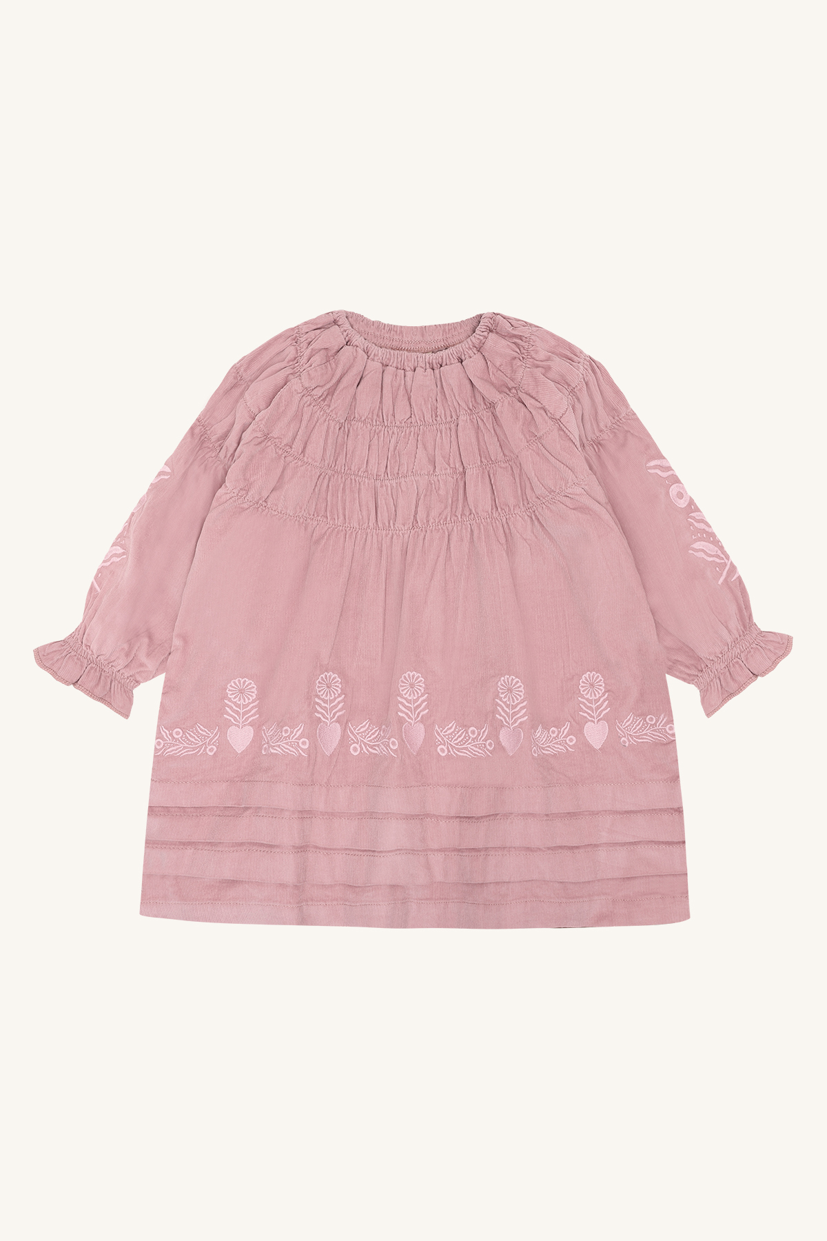 Frontbilde av en rosa langermet kjole med rynket hals, blomster- og hjertebroderi og volangmansjetter.