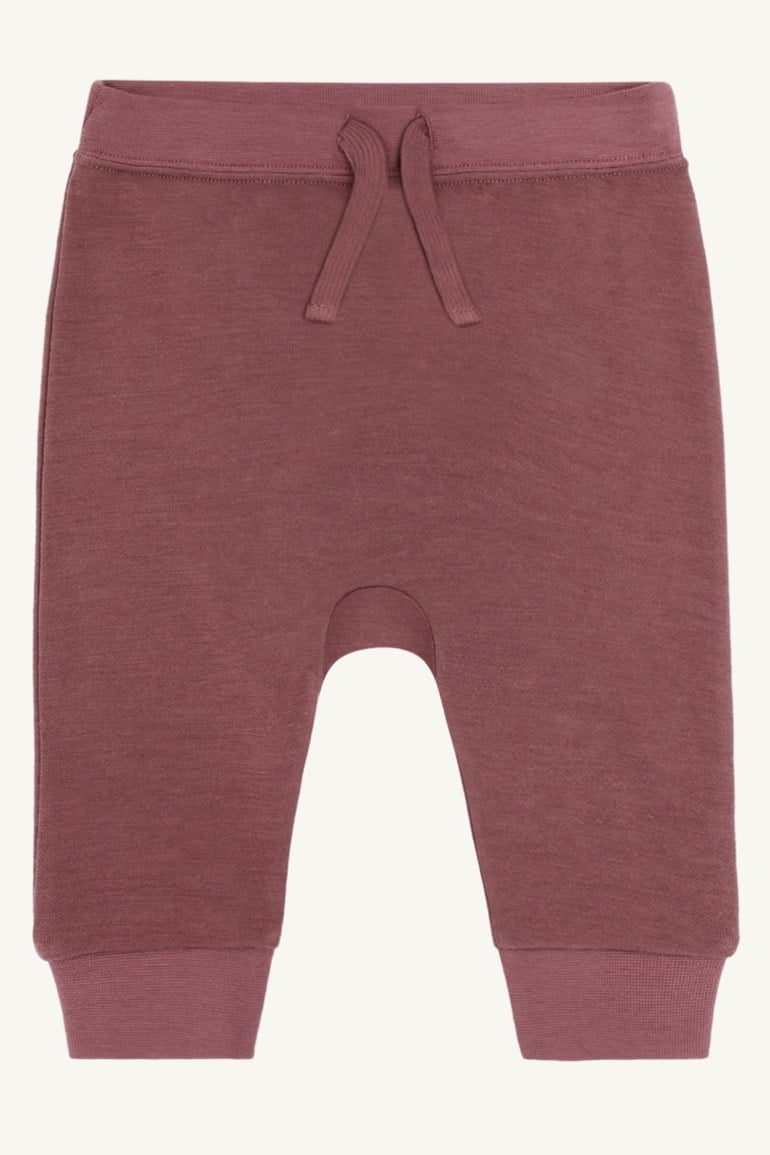 Mørkrosa babyjoggebukse med snøring i midjen og ribbestrikkede mansjetter, forfra.