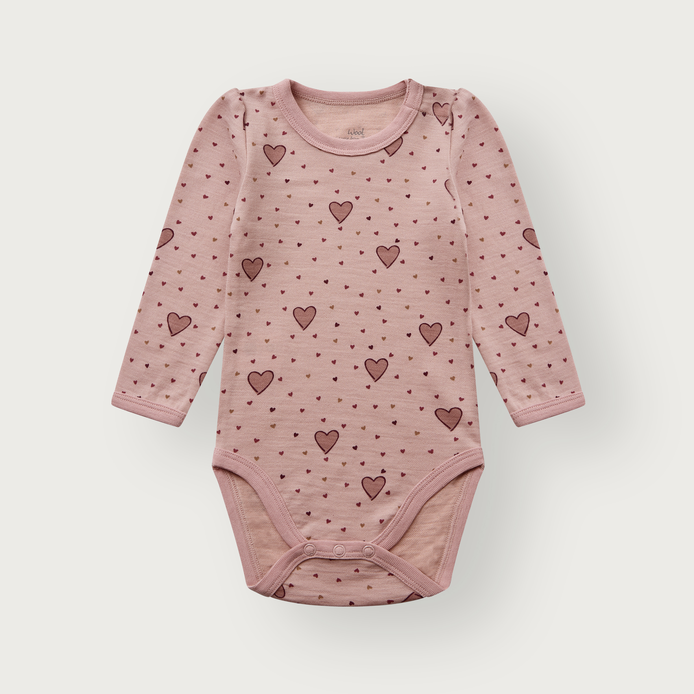 Babyens støvrosa langermet body med hjertemønster og trykknapper, forfra.
