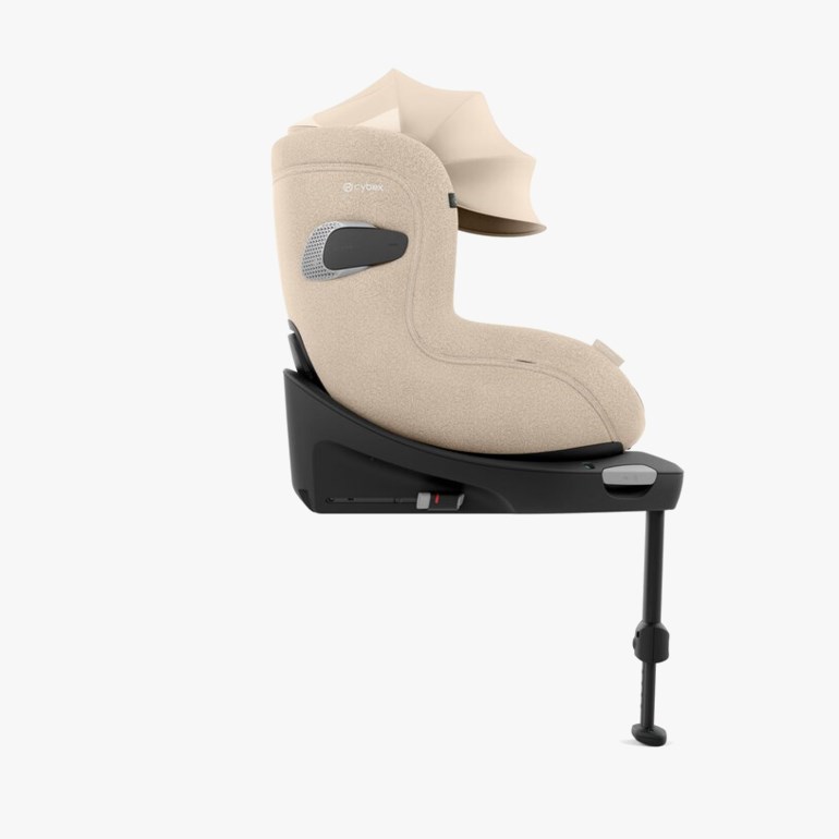 Beige babybilsete med kalesje på en svart ISOFIX-base og støtteben, sidevisning.