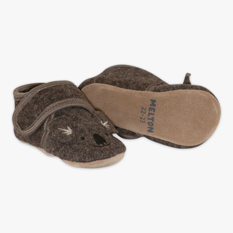 Brune babysko i filt med koaladesign og borrelås, en såle er synlig.